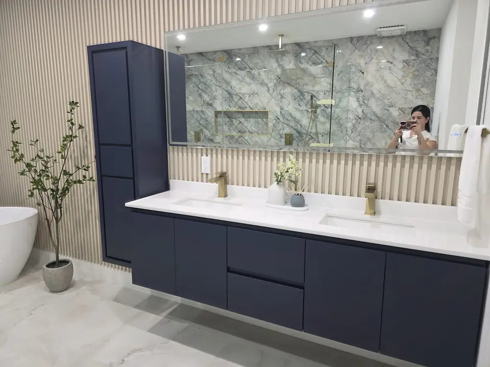 Navy floating double vanity with marble feature wall and oak slat paneling